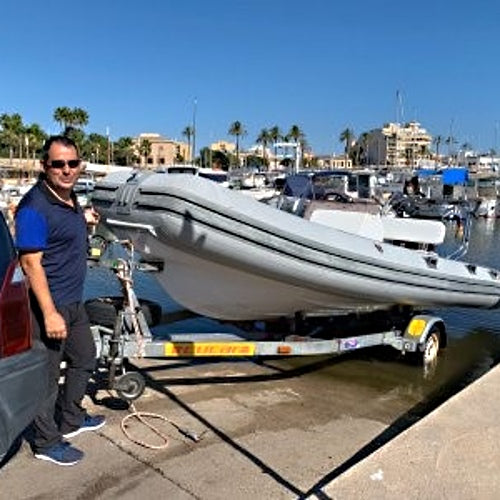 zu sehen ist ein Mann mit Schlauchboot, das ins Wasser gelassen wird