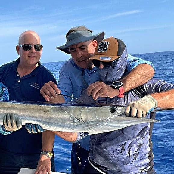 zu sehen sind 3 Fliegenfischer die einen großen Fisch vor der Brust halten